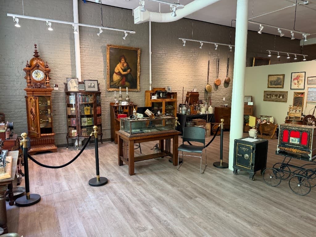 The Beautiful Things galleries at the Occidental Fine Arts Center: paintings, a tall clock and display cases.
